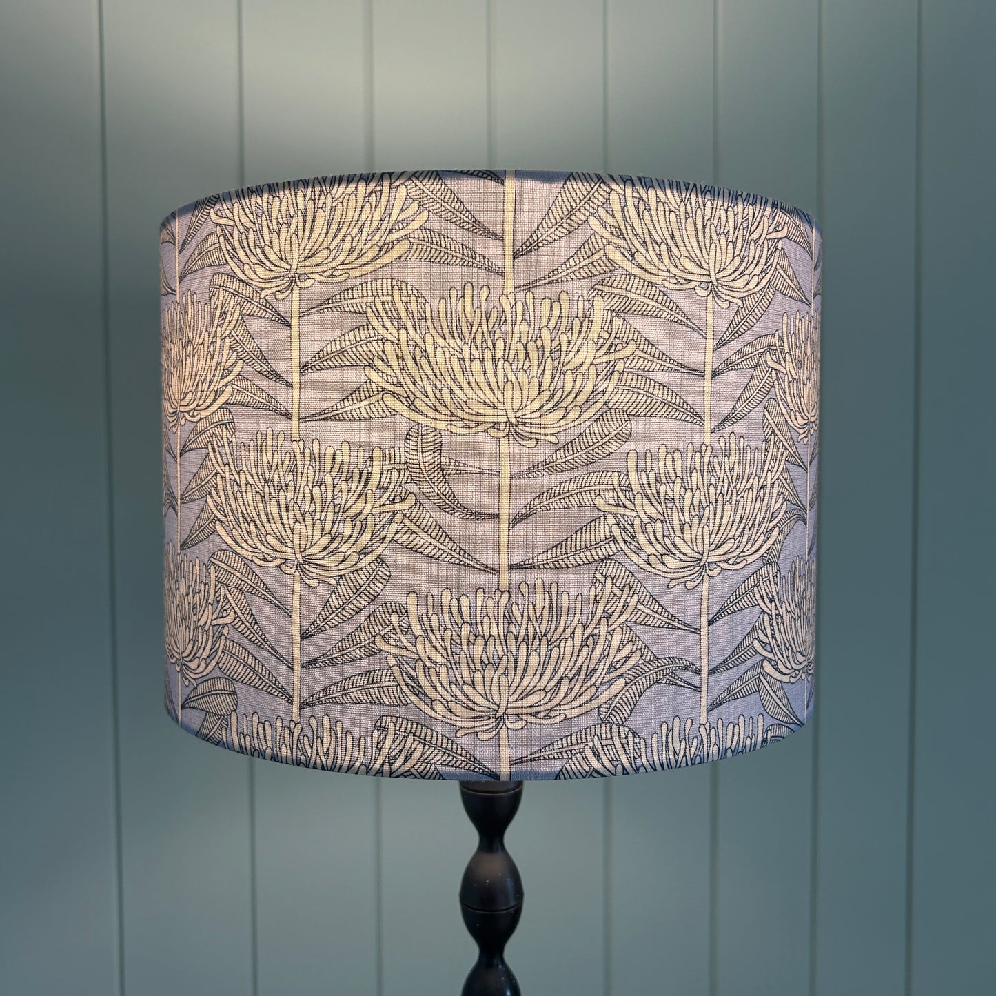 Floral patterned lampshade with protea botanical native floral design fabric with light on to show light diffusion