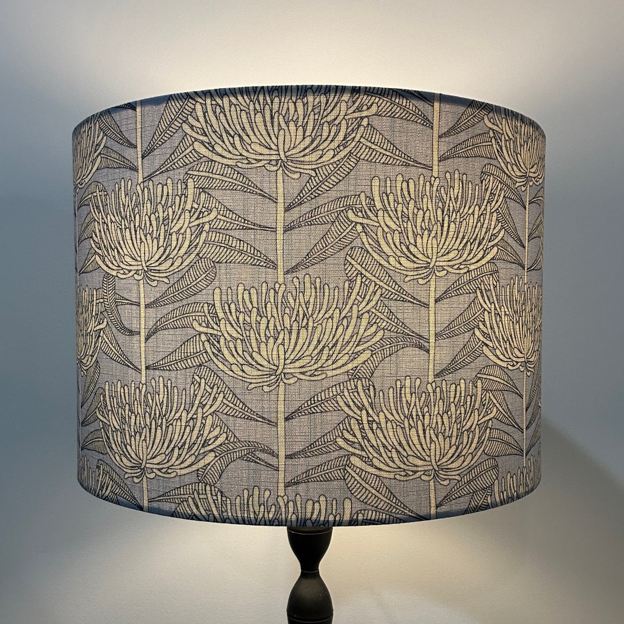 Powder blue protea pattern lampshade, lit up by lamp