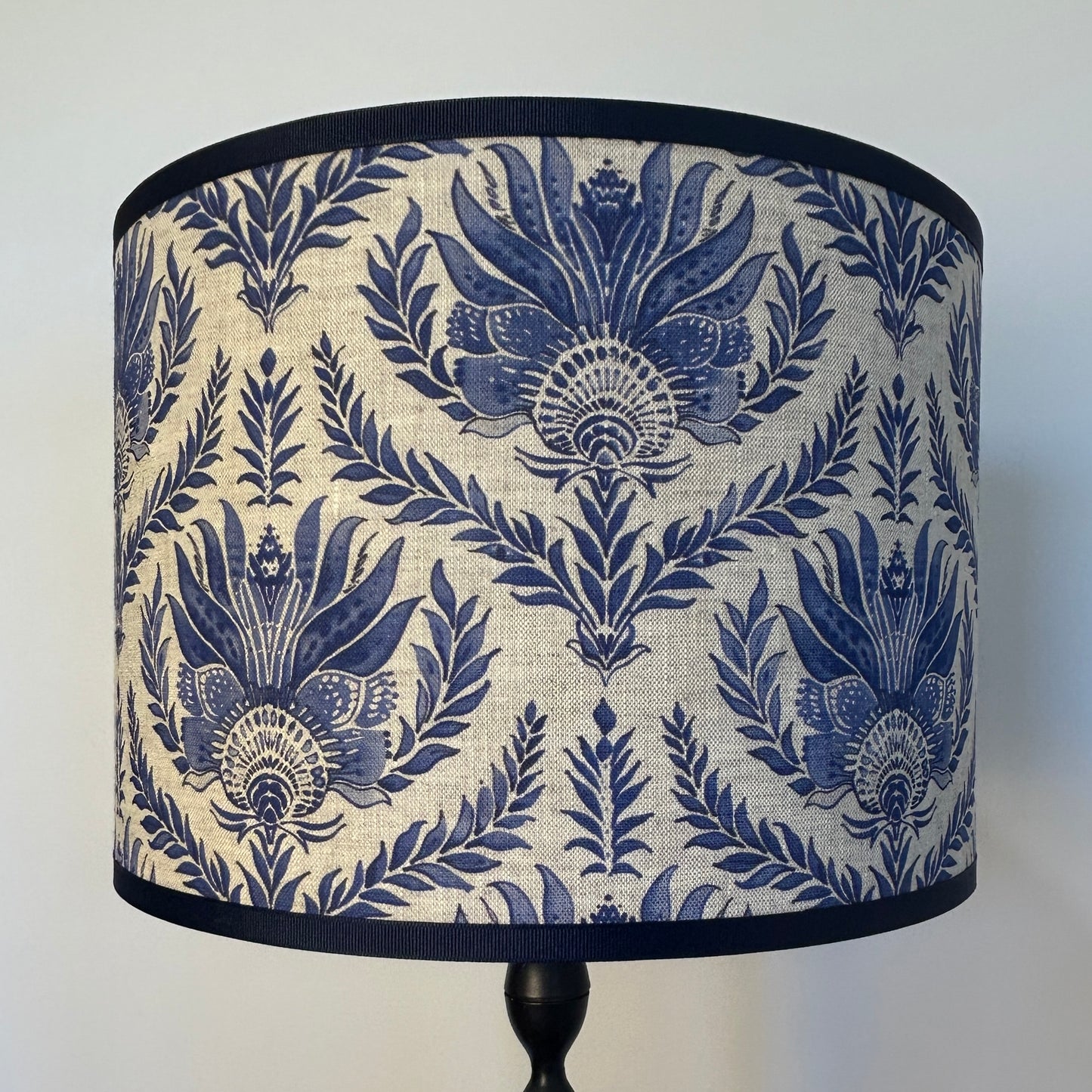 French blue block print pattern genuine linen lampshade with light on showing weave texture