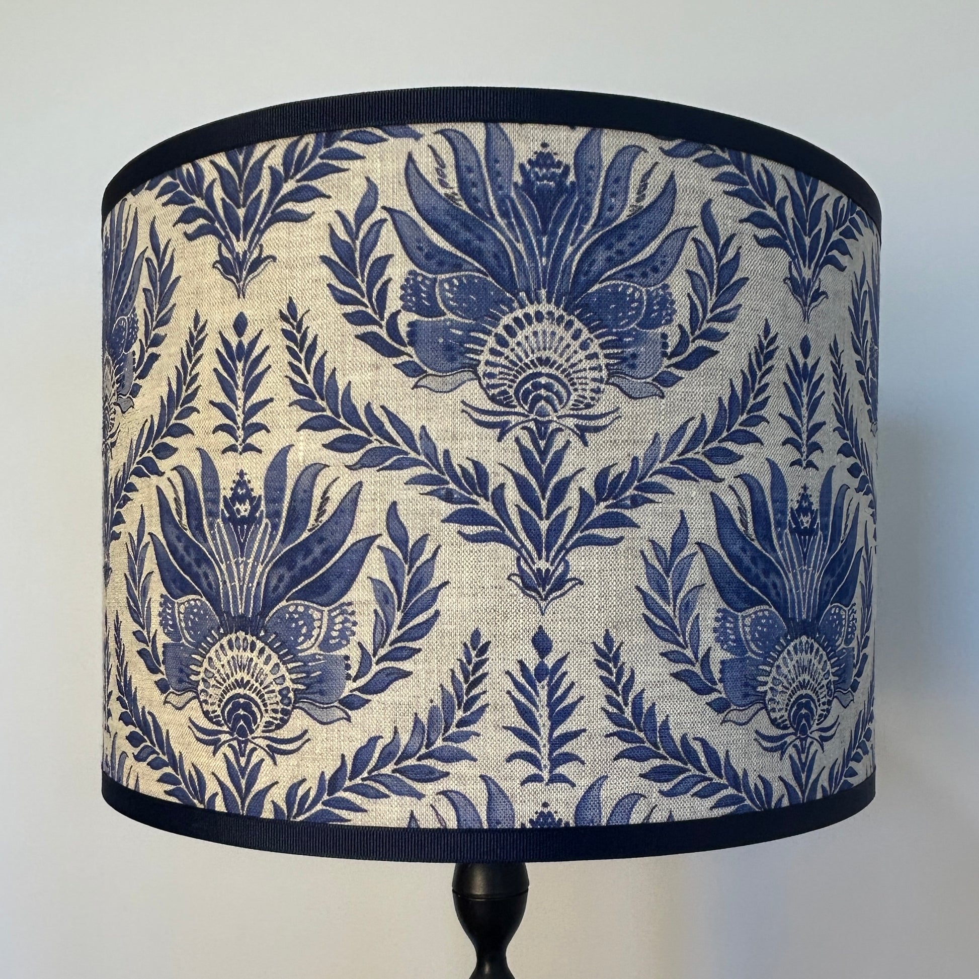 French blue block print pattern genuine linen lampshade with light on showing weave texture