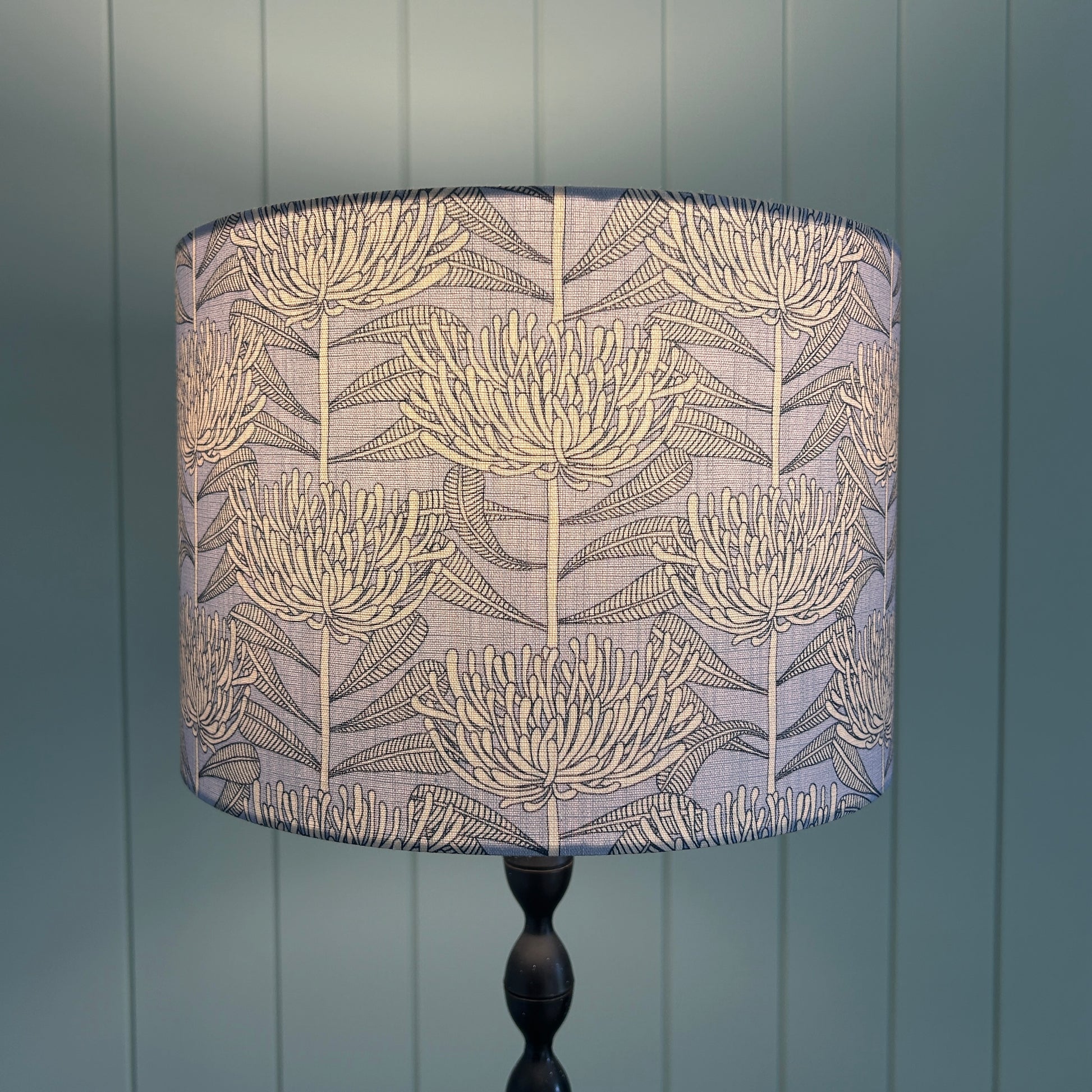 Floral patterned lampshade with protea botanical native floral design fabric with light on to show light diffusion